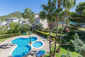 an aerial view of a resort with two pools and palm trees at ORO DEL MAR IV Apartamento O2 in Canyamel