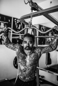 a man with tattoos on his arms in a gym at MAI Villa Da Nang in Danang