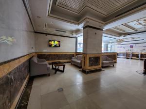 a lobby with couches and a tv on a wall at Quiet Dreams - Quraysh Branch in Jeddah