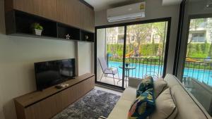 uma sala de estar com um sofá e uma televisão de ecrã plano em La Casita pool access condo HuaHin em Hua Hin