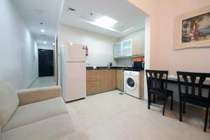 a kitchen with a white refrigerator and a table and chairs at Studio Apartment in Zumurud Tower , Dubai Marina in Dubai