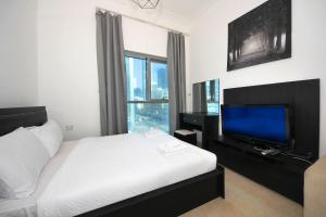 a bedroom with a bed and a flat screen tv at Studio Apartment in Zumurud Tower , Dubai Marina in Dubai