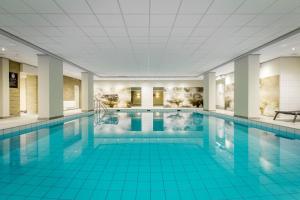 a large swimming pool with a blue tile floor at Fletcher Hotel-Restaurant Frerikshof in Winterswijk