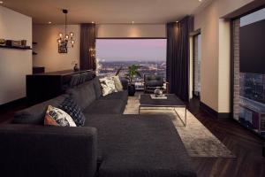 a living room with a couch and a large window at Van der Valk Hotel Amsterdam - Amstel in Amsterdam