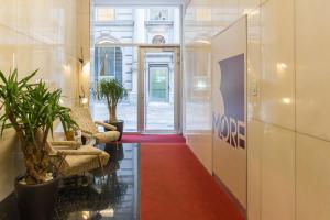 a lobby with two chairs and a red carpet at BMORE Apartments in Milan