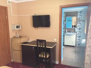 a room with a desk and a television on the wall at Patio MiniHotel in Tolyatti