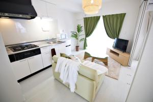 a living room with a couch and a kitchen at Vent du Vent301 in Minatogawa