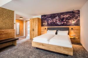 a bedroom with a bed and a painting on the wall at Ringhotel sKreuz in Steinheim am Albuch +75 photos