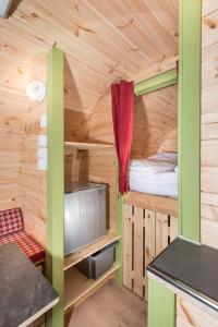 uma cabana de madeira com uma cama e uma televisão em Remsfass em Schwäbisch Gmünd