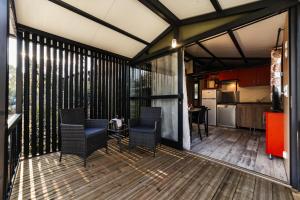 una veranda riparata con sedie, tavolo e cucina di Oasi Camping a Diano Marina