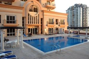 a large swimming pool in front of a building at SHH- Studio Apartment Venetian Tower, Sports City in Dubai