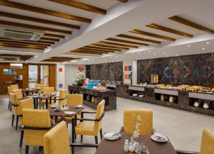 a restaurant with tables and chairs and a buffet at Sobit Sarovar Portico in Palolem