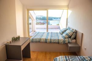 Pokój z łóżkiem, biurkiem i oknem w obiekcie James w mieście Pješčana Uvala