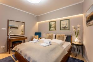 una camera da letto con un letto e due asciugamani di Ambria Apartments Dune a Świnoujście
