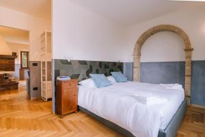 a bedroom with a large white bed with an archway at Villa De Castelletta Relais in Rapagnano