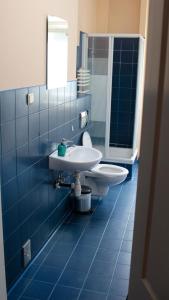 ポズナンにあるPit Stop Hostelの青いタイル張りのバスルーム(洗面台、トイレ付)