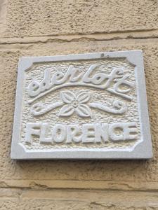 a sign on the side of a building with a flower at Eden Loft Firenze in Florence