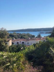 a house on the hill with a view of the water at Appartamento Gli Oleandri 138 - Costa Smeralda-Porto Cervo in Liscia di Vacca