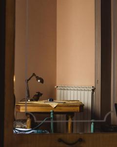 un escritorio con una lámpara en una habitación en Casa Verdi - House of Travelers en Catania