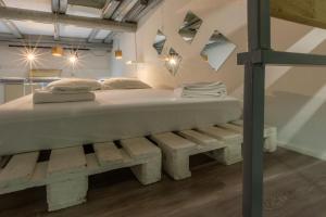 uma grande cama branca com um banco num quarto em Casa Cerami em Catânia