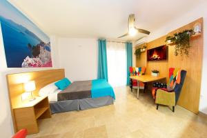 1 dormitorio con cama, escritorio y mesa en Zenplaya Bajo 12 Terraza interior, en Torremolinos