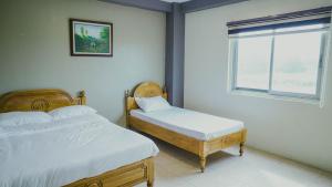 Urdaneta的住宿－2428 Suites，一间卧室设有两张床和窗户。