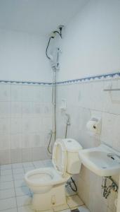 a bathroom with a shower and a toilet and a sink at 2428 Suites in Urdaneta