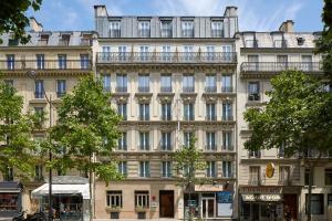 巴黎的住宿－Hôtel LOCOMO，一座白色的大建筑,有很多窗户