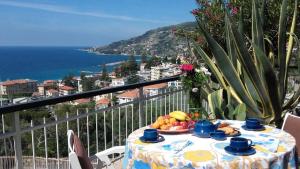 a table with a plate of fruit on a balcony at Gioiello sul mare in Ospedaletti