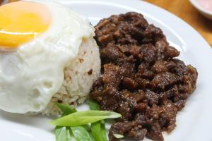 a plate of food with a fried egg and rice at 2428 Suites in Urdaneta