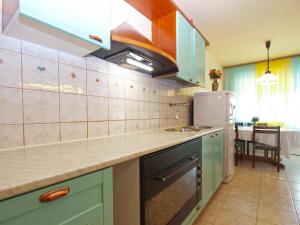 a kitchen with green cabinets and a refrigerator at Apartment Momcilo 1995 in Pula