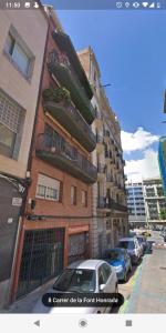 een gebouw waar auto's voor geparkeerd staan bij Idyllic Apartment with Terrace in Barcelona