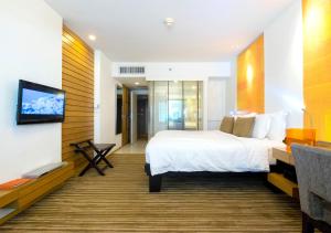 a hotel room with a bed and a flat screen tv at dusitD2 Chiang Mai in Chiang Mai