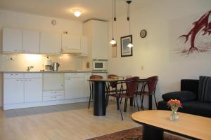 eine Küche und ein Wohnzimmer mit einem Tisch und Stühlen in der Unterkunft Appartement 19 Callantsoog in Callantsoog