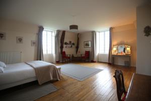 una camera con letto, tavolo e sedie di La Sicorie a Saint-Germain-le-Guillaume