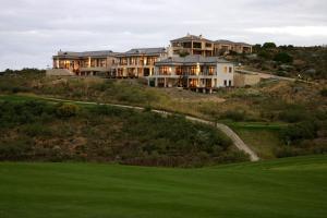 una casa grande en la cima de una colina con un patio verde en World's View Knysna en Knysna