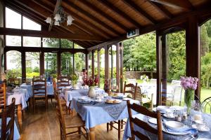 a dining room with tables and chairs and windows at Toghill House Farm in Wick