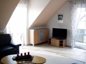 a living room with a couch and a tv at Ferienwohnung Hartinger in Wolfersdorf