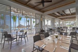 a restaurant with tables and chairs and windows at Bahia Principe Grand Aquamarine - Adults Only All Inclusive in Punta Cana