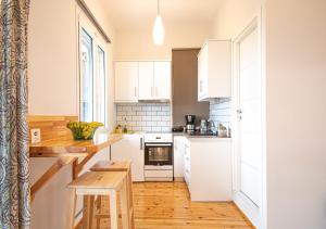 a kitchen with white cabinets and a wooden floor at Blue Window in Finikounta
