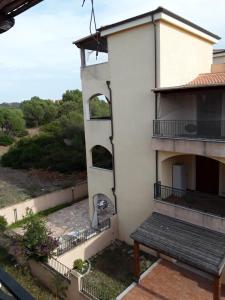 ein Apartmentgebäude mit einem Balkon und einer Bank in der Unterkunft Da Claudio gli oleandri residence in Olbia