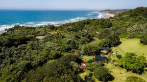 an aerial view of a house on a hill next to the ocean at Kingfisher Lakeside Retreat in Trafalgar