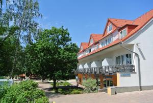 ein großes weißes Gebäude mit rotem Dach in der Unterkunft Bernsteinsee Hotel in Sassenburg
