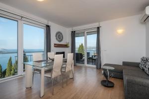 a living room with a table and chairs and a couch at Apartments Didan in Cavtat