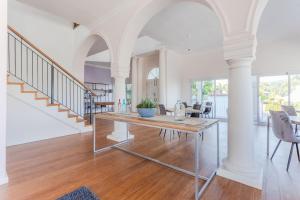 a living room with a table and a staircase at The Views Guesthouse in Somerset West