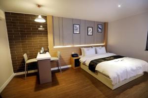 - une chambre avec un lit, une table et un bureau dans l'établissement Hotel Two Heart, à Daegu