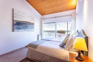 a bedroom with a large bed and a large window at Casa Bom Porto in Luz +34 photos