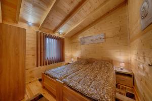 - une chambre avec un lit dans une cabane en rondins dans l'établissement Rejan Lux, à Ulcinj