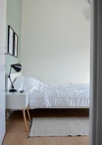 a bedroom with a white bed and a lamp on a table at Hygge Home at Trikala in Tríkala