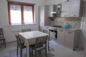 a kitchen with a table and chairs and a stove at La rosa dei venti, apartment 1 in Porto Empedocle